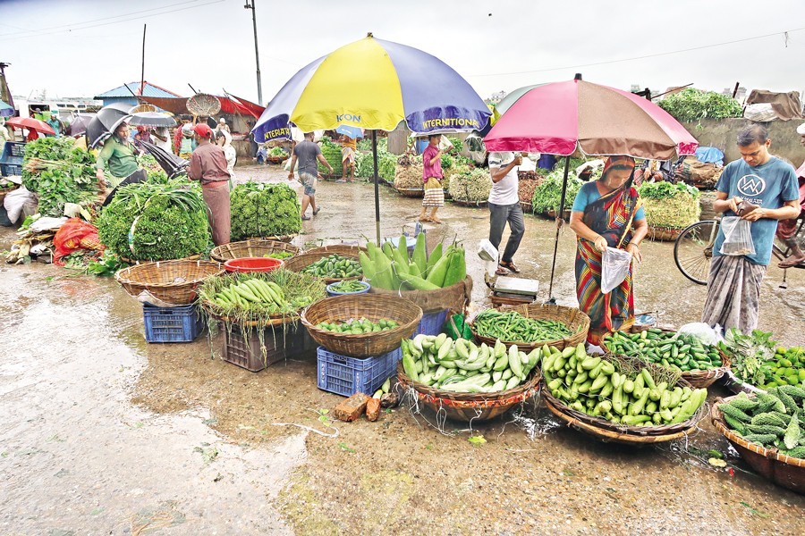 Heavy rainfall triggered by a deep depression in the Bay of Bengal on Thursday kept customers away from Shyampur's wholesale market in Dhaka. Due to the thin presence of buyers, local traders struggled to sell vegetables, leading to a steep fall in prices. Many sellers were forced to sell the perishable items at much lower rates to avoid spoilage, resulting in heavy losses. — FE Photo by Shafiqul Alam
