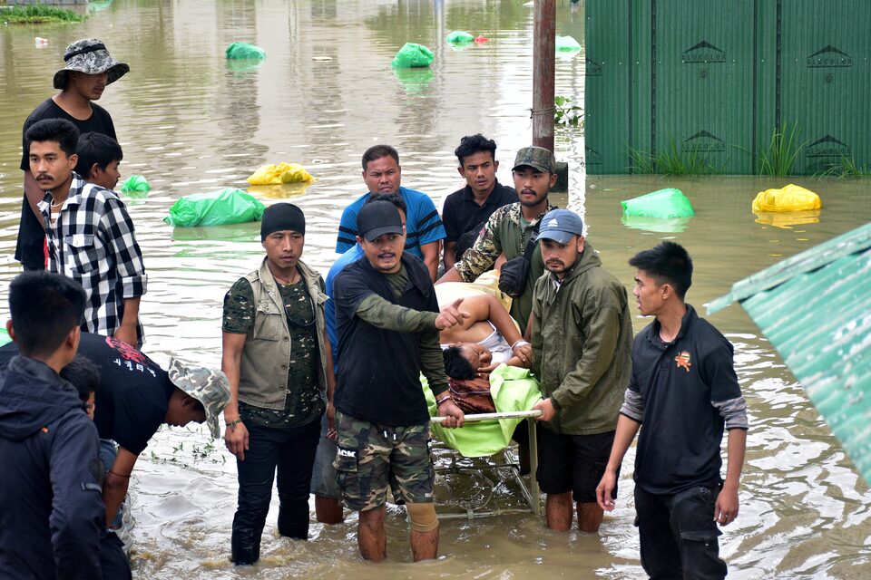 People carry a patient on a stretcher as they wait for a rescue boat to evacuate him from the flood-affected Jawaharlal Nehru Institute of Medical Sciences hospital, following heavy rains in Imphal East, Manipur, India June 1, 2025. REUTERS/Stringer