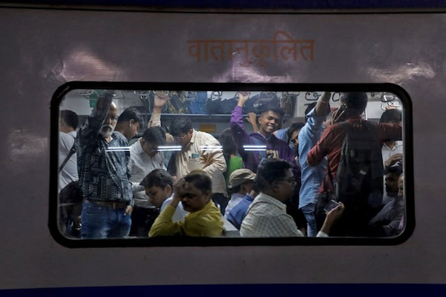 Commuters travel in a crowded compartment of a suburban train in Mumbai, India, January 20, 2023.