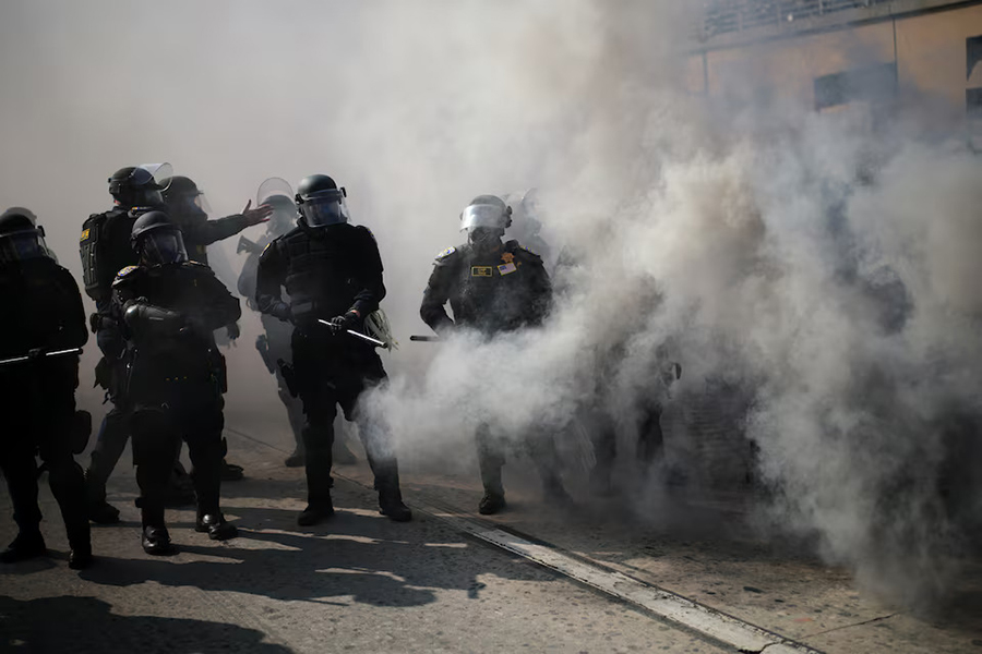 Police officers stand amid tear gas during a protest against federal immigration sweeps in downtown Los Angeles, California, US on June 8, 2025 — Reuters photo