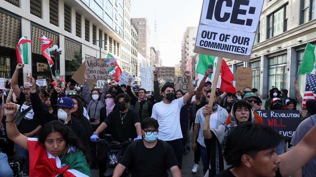 Demonstrators hold signs and flags during a protest against federal immigration sweeps in downtown Los Angeles, California, US June 10, 2025. REUTERS