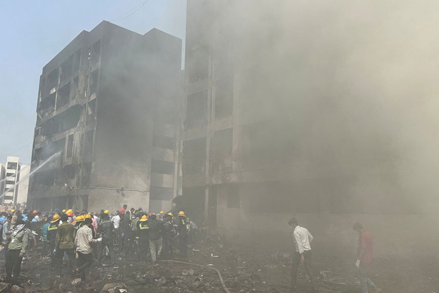 Rescue team members work as smoke rises at the site where an Air India plane crashed in Ahmedabad, India, June 12, 2025.