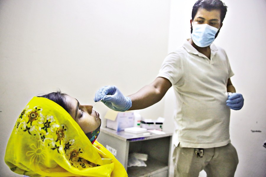 A woman undergoes a nasal swab test at DNCC Dedicated Covid-19 Hospital in Dhaka's Mohakhali on Thursday, as a fresh wave of the respiratory disease is feared amid growing cases. — FE Photo by K Asad-Uz-Zaman