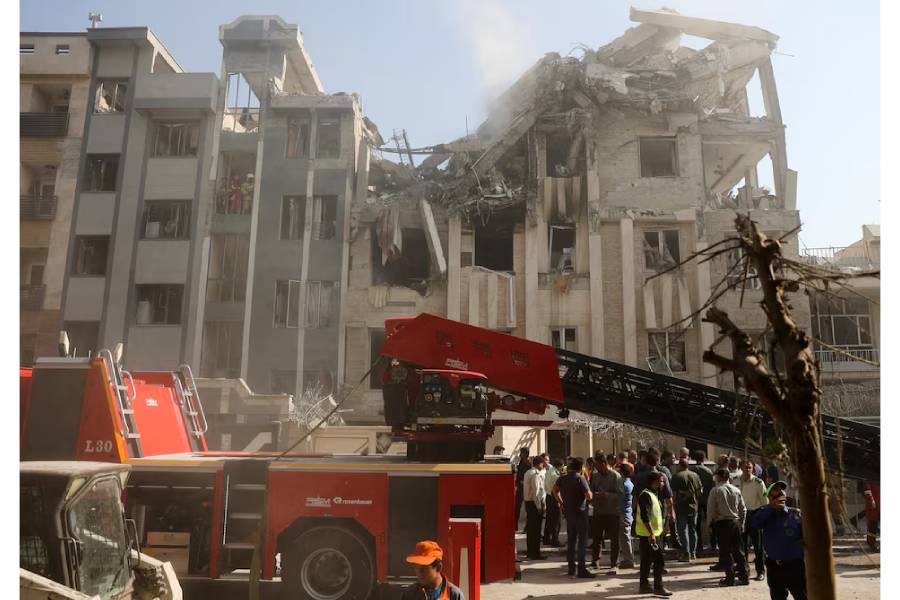 Rescuers work at the scene of a damaged building in the aftermath of Israeli strikes, in Tehran, Iran, June 13, 2025.