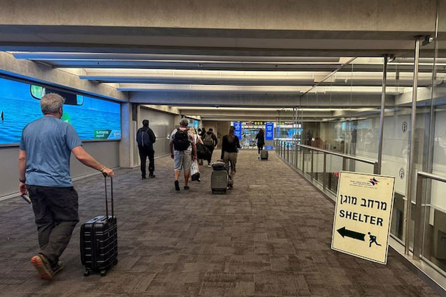 People walk next to a sign directing for Shelter after landing in Israel at the arrivals section of Ben Gurion International airport in Lod near Tel Aviv, Israel October 11, 2023.