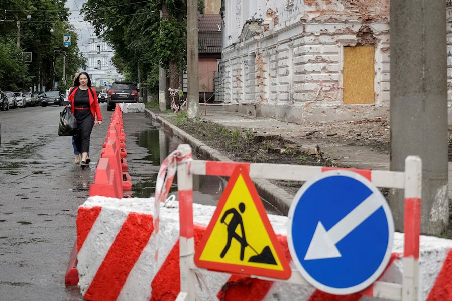 A resident walks at a street near a building damaged by Russian missile strikes, amid Russia's attack on Ukraine, in Sumy, Ukraine June 13, 2025.