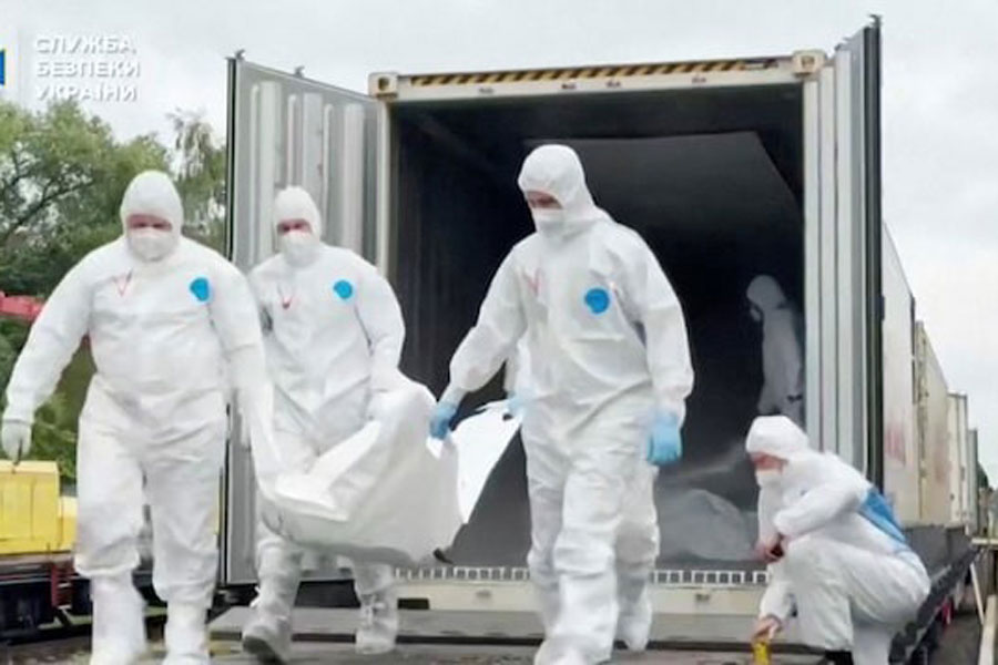 People in hazmat suits carry what is said to be remains of Ukrainian soldiers received from Russia in an unknown location in a screen grab from a Handout video released on June 13, 2025.