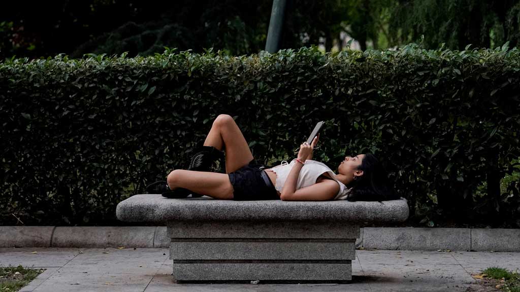 A person lies on a public bench during a hot day in Madrid, Spain, June 1, 2025. REUTERS