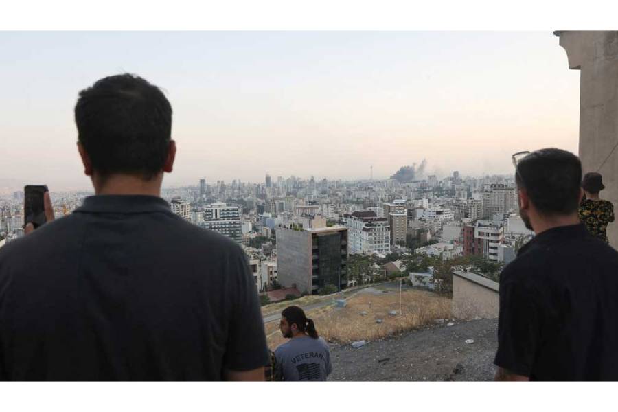 People watch as smoke rises following an Israeli attack on the IRIB building, the country’s state broadcaster, in Tehran, Iran, June 16, 2025.