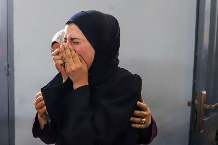 A woman reacts as Palestinians, wounded in an Israeli strike, according to the Gaza Health Ministry, receive treatment at Al-Shifa hospital in Gaza City, June 19, 2025.