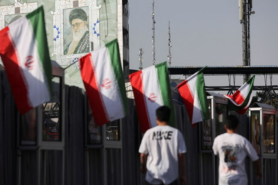 People walk near a mural of Iran's Supreme Leader, Ayatollah Ali Khamenei, amid the Iran-Israel conflict, in Tehran, Iran on June 23, 2025 — WANA (West Asia News Agency) via REUTERS
