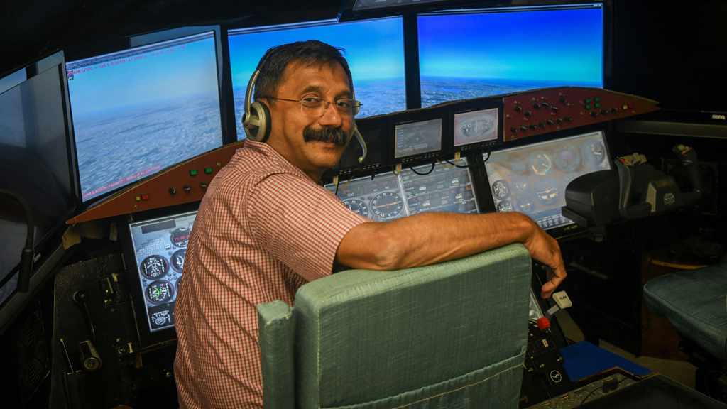 Retired Indian Air Force (IAF) wing commander K Dinesh poses for pictures in a cockpit simulator room, after an interview with Reuters, at Cockpit Vista in Bengaluru, India Jun 23, 2025. REUTERS/Meghana Sastry