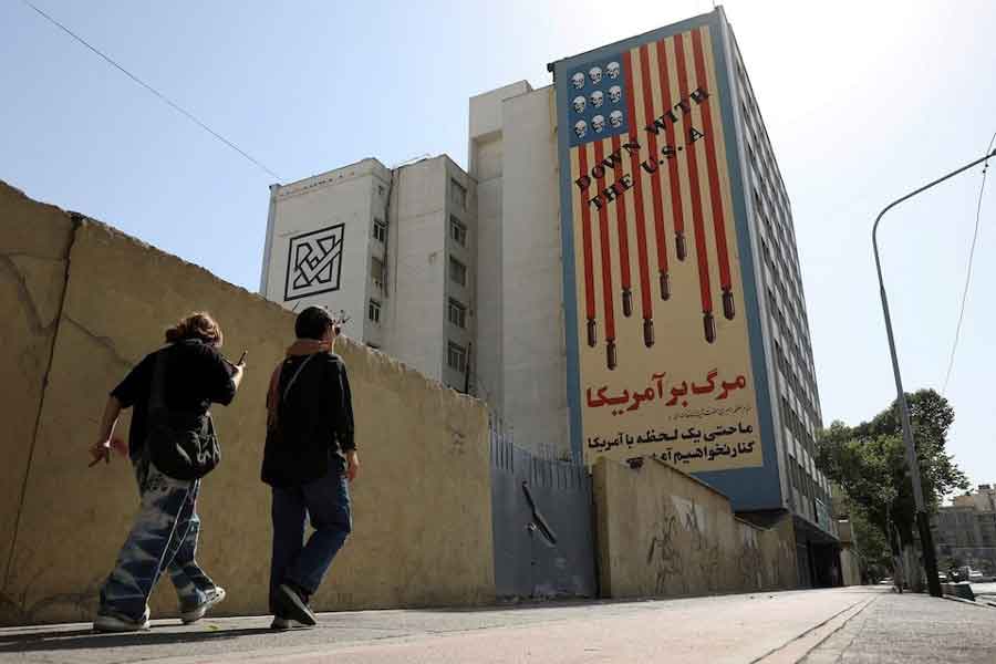 People walk past an anti-US mural on a street in Tehran, Iran, June 5, 2025.