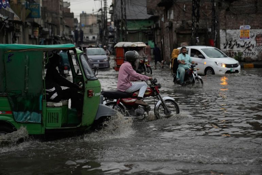 Motorists drive on a road flooded by heavy monsoon rains in Lahore, Pakistan.