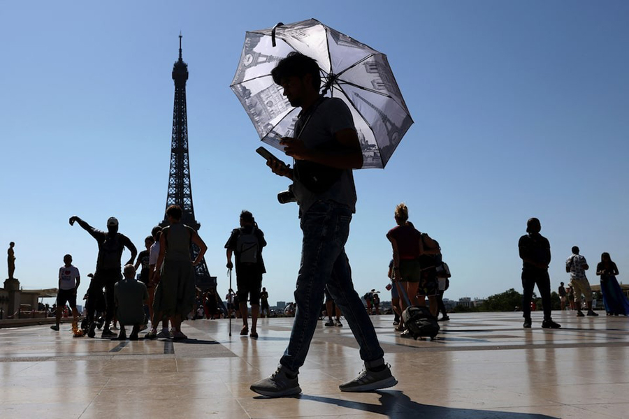 A tourist holding an umbrella to protect himself from the sun walks at Trocadero square next to the Eiffel Tower as an early summer heatwave hits Paris, France — Reuters photo