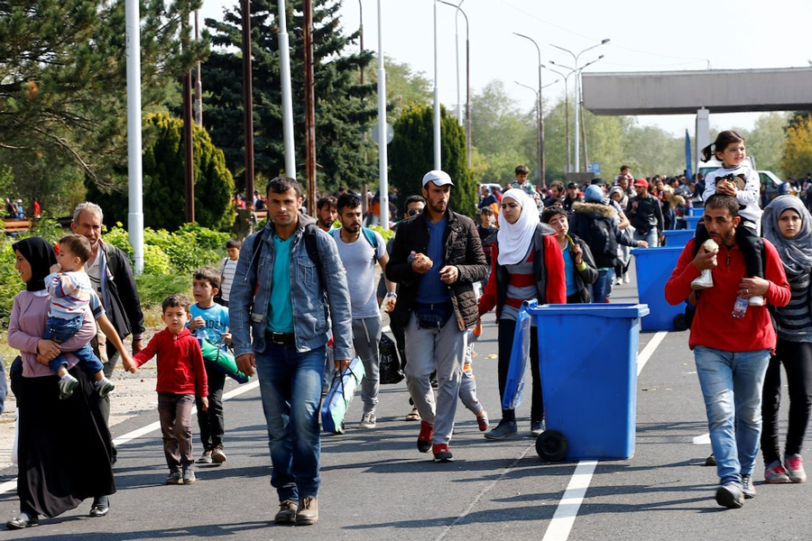 Migrants pass by garbage bins as they walk towards the Austrian border from Hegyeshalom, Hungary , September 23, 2015.
