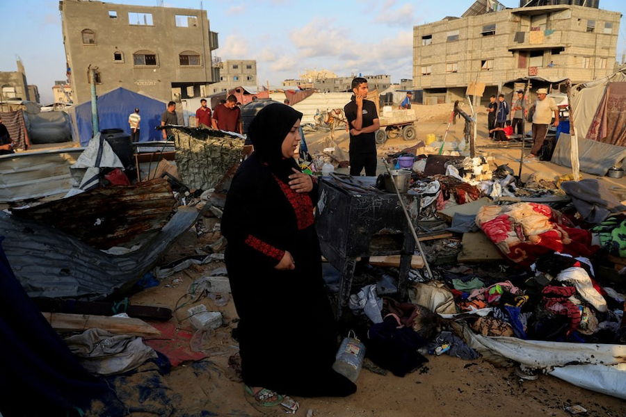 Palestinians inspect the damage at the site of an overnight Israeli air strike on a tent sheltering displaced people, in Khan Younis, southern Gaza Strip.