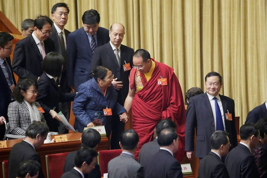 Gyaltsen Norbu, the 11th Panchen Lama and a delegate of Chinese People's Political Consultative Conference (CPPCC), speaks to an elderly delegate as they leave after the opening session of the Chinese People's Political Consultative Conference at the Great Hall of the People in Beijing, China, March 3, 2019.