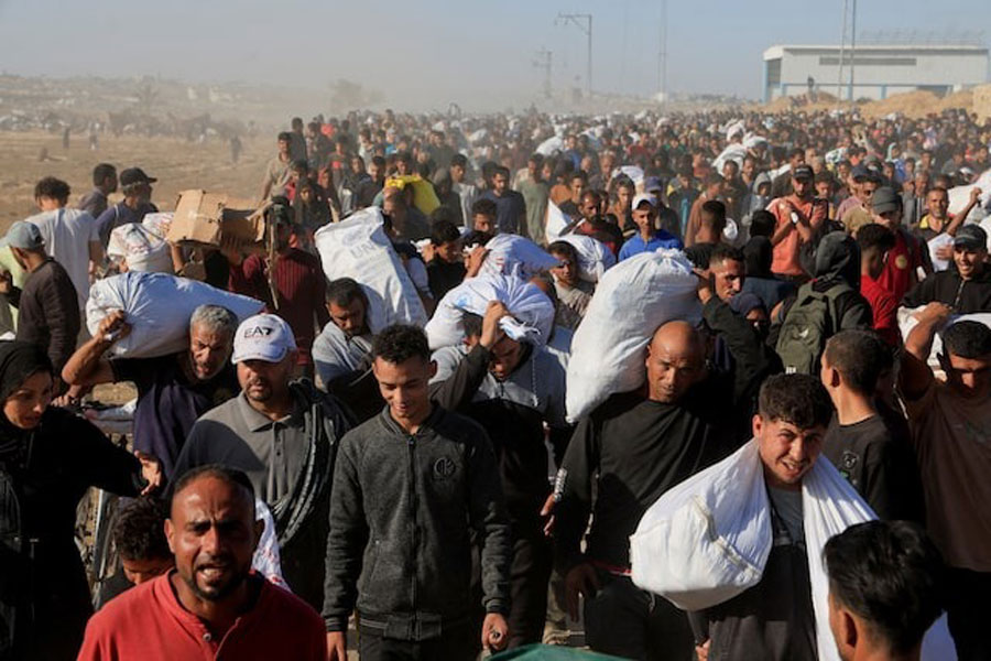 Palestinians carry aid supplies from the US-backed Gaza Humanitarian Foundation, in Khan Younis, in the southern Gaza Strip, May 29, 2025.