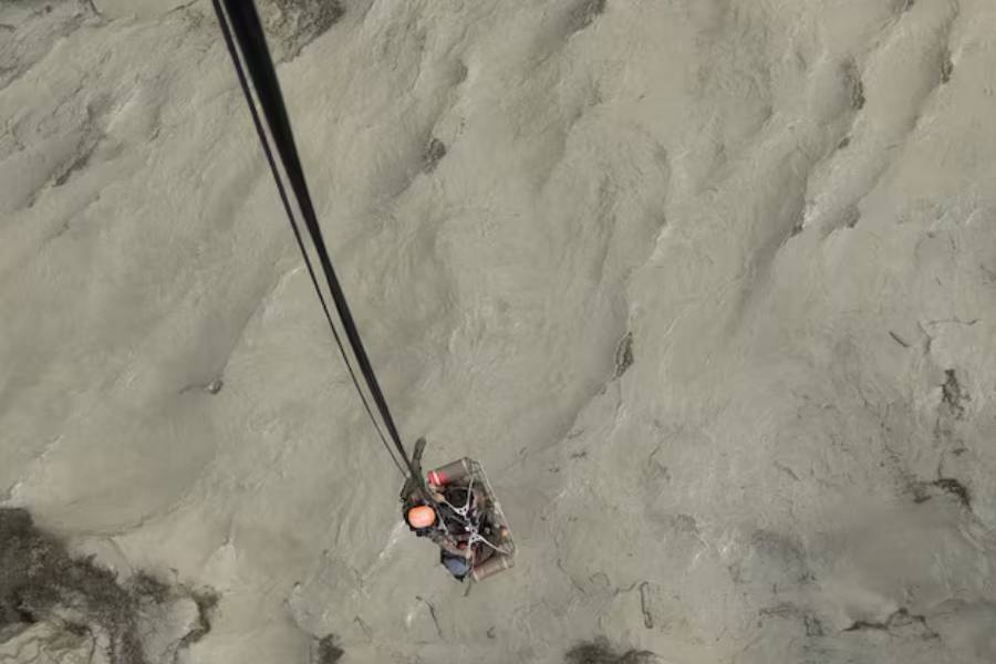 A member of the Nepalese army airlifts people stranded during the flood at Bhotekoshi river, Nepal, July 8, 2025.