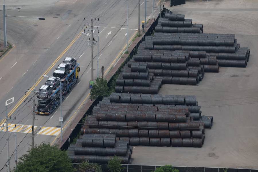 A car carrier transporting vehicles made by KGM, travels past steel products at Pyeongtaek port in Pyeongtaek, South Korea, July 8, 2025.