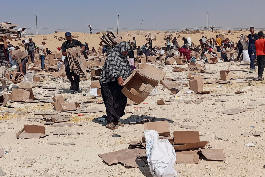Palestinians gather to collect what remains of relief supplies from the distribution center of the US-backed Gaza Humanitarian Foundation, in Rafah, in the southern Gaza Strip, June 5, 2025.