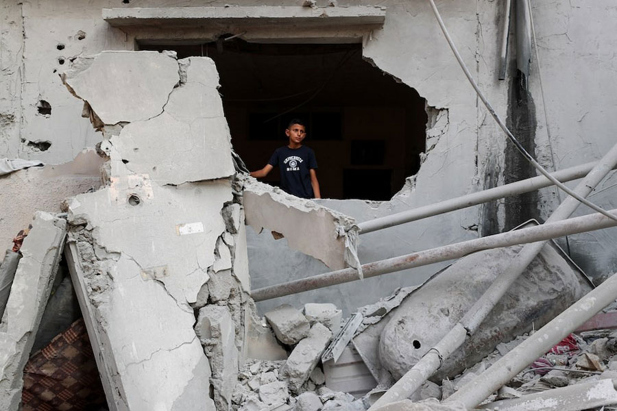 A Palestinian child stands at the site of an overnight Israeli air strike on a house, in Gaza City, July 11, 2025.
