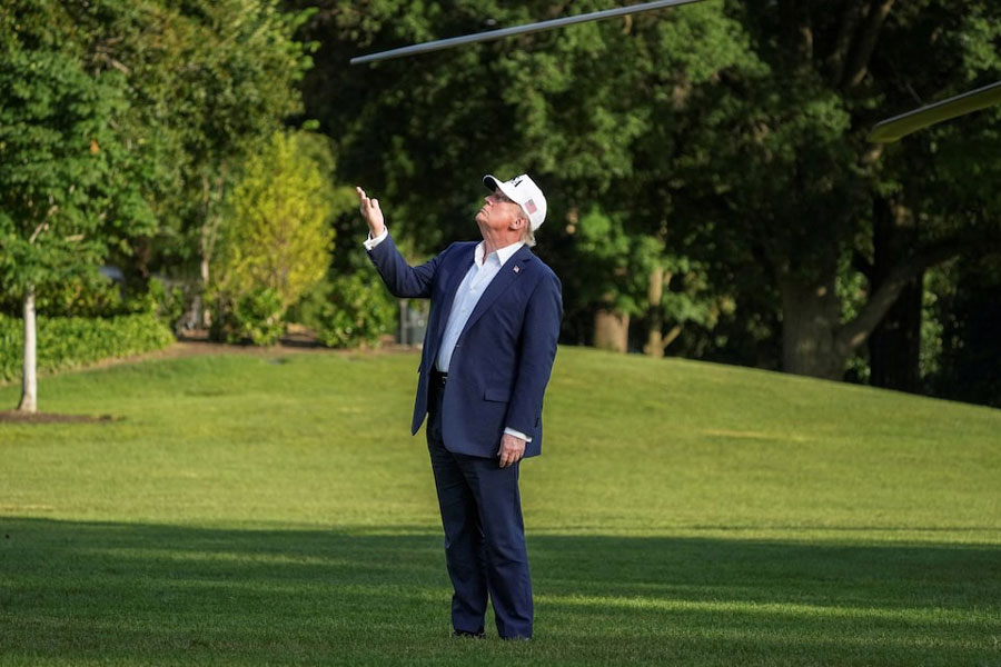 US President Donald Trump gestures to the US flag flying on a new flagpole after stepping off Marine One returning from New Jersey at the White House in Washington, DC, US, July 6, 2025.