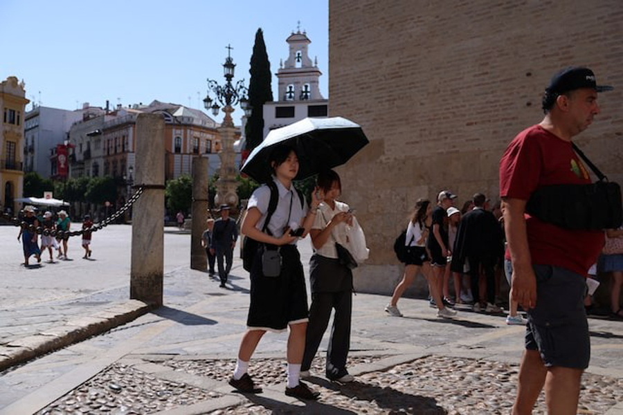 People walk during a heatwave, in Seville, Spain, July 2, 2025.