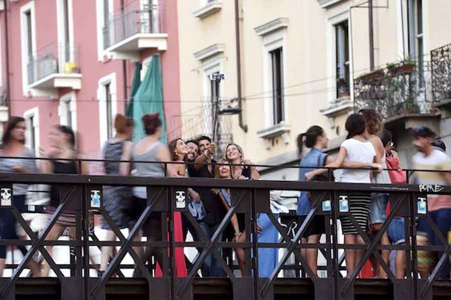 People take a selfie at Naviglio Gran Canal in Milan, August 29, 2015.