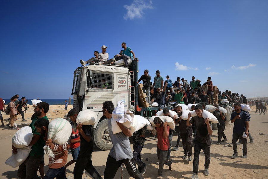 Palestinians carry aid supplies that entered Gaza through Israel, amid a hunger crisis, in Beit Lahia in the northern Gaza Strip July 20, 2025.