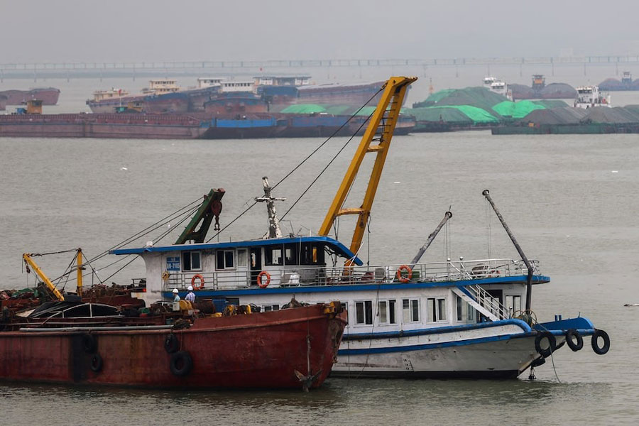 A tourist boat (in white) that capsized in an accident which killed dozens and left several people still missing, is towed back to the port in Halong Bay, Quang Ninh province, Vietnam, July 20, 2025.