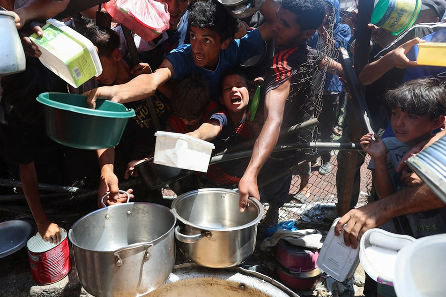 Palestinians gather to receive food from a charity kitchen, amid a hunger crisis, in Nuseirat, central Gaza Strip on July 20, 2025 — Reuters photo