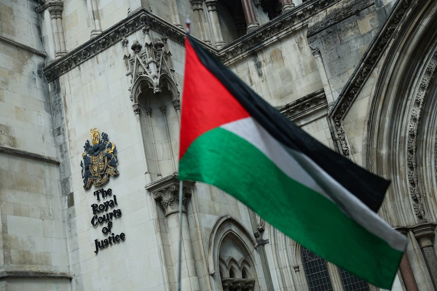 A person holds a Palestinian flag outside the High Court on the day of a hearing about the banned pro-Palestinian campaign organisation Palestine Action, in London, Britain, July 21, 2025.