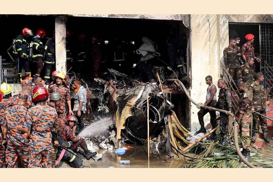 Firefighters and army members work next to the wreckage of an air force training aircraft after it crashed into Milestone College campus, in Dhaka, Bangladesh, Jul 21, 2025.