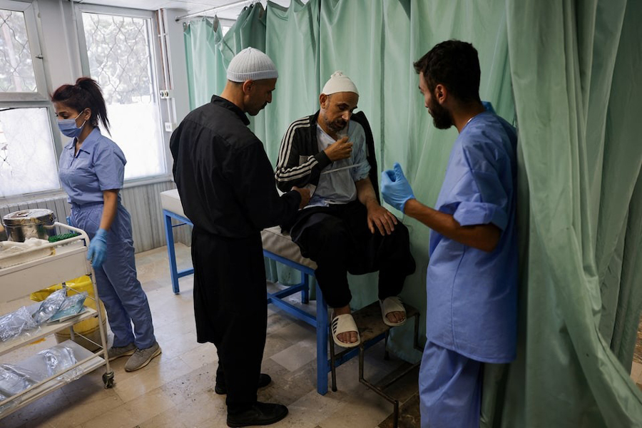 A health worker assists a man at a hospital, following deadly clashes between Druze fighters, Sunni Bedouin tribes and government forces, in Syria's predominantly Druze city of Sweida, Syria July 25, 2025.