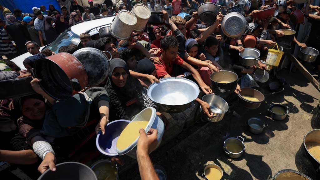 Palestinians gather to receive food from a charity kitchen, amid a hunger crisis, in Gaza City, July 25, 2025. REUTERS