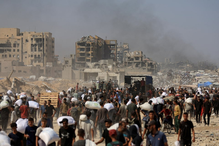 Palestinians carry aid supplies that entered Gaza through Israel, in Beit Lahia in the northern Gaza Strip, July 27, 2025.