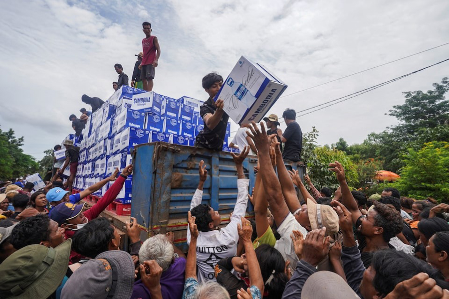 People gather to receive water supplies donated at Batthkao Primary School camp, amid ongoing clashes on the Thai-Cambodian border that extended to the third day, with new flashpoints emerging as both sides seek diplomatic support and urge for negotiations, in Oddar Meanchey province, Cambodia, July 26, 2025.