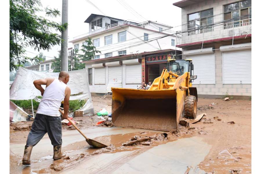 Villagers clear the mud from a street after heavy rainfall flooded Yi county of Baoding, Hebei province, China July 26, 2025.