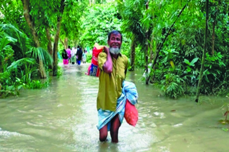 A man wading through knee-deep water in a flash flood-hit area of Chnadpur town