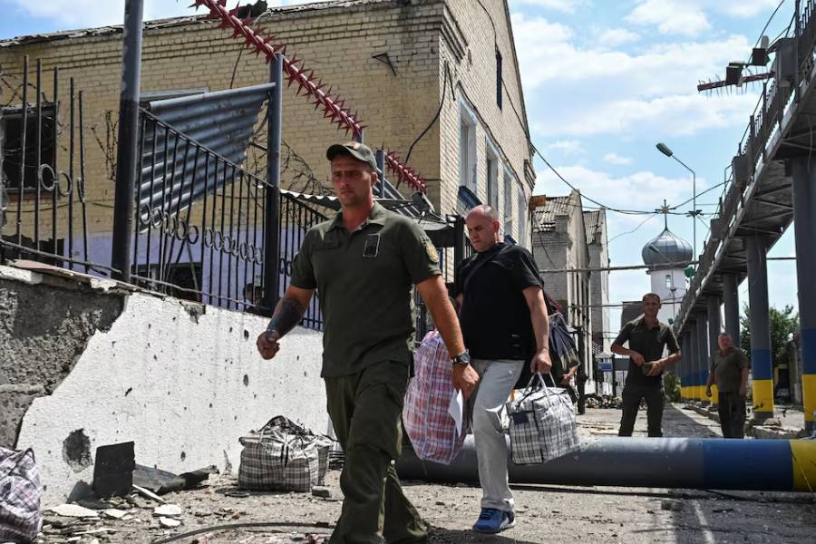 A serviceman accompanies a prisoner at the site of the penal colony hit by a Russian air strike, amid Russia's attack on Ukraine, in Zaporizhzhia region, Ukraine July 29, 2025.