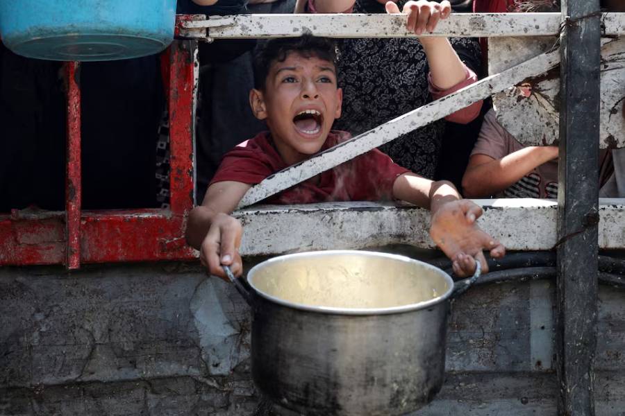A Palestinian reacts as he waits to receive food from a charity kitchen, amid a hunger crisis, in Gaza City, July 28, 2025.