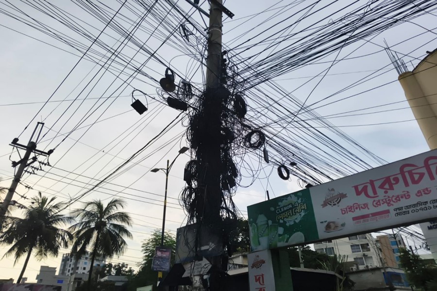 Intertwined electricity, internet and TV connection cables hang overhead in Padma residential area of Rajshahi city