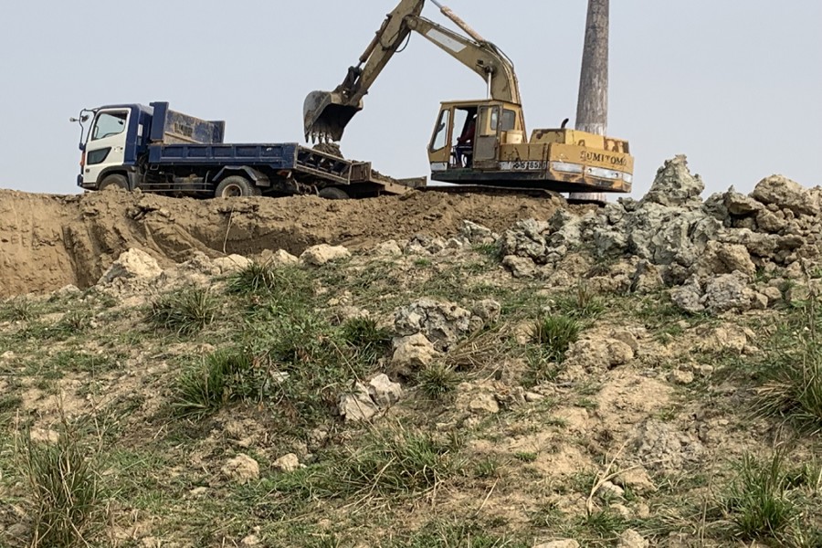 A hillock is being flattened by using excavator in Golapganj upazila of Sylhet distri