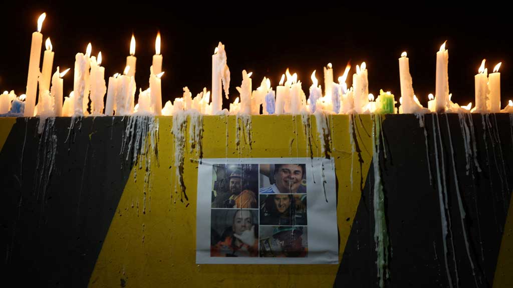 A print showing photos of miners trapped in the El Teniente mine complex, operated by Chilean state-run copper producer Codelco, is displayed during a candlelight vigil as rescue teams continue efforts to reach those trapped following a tremor at the Andesita unit, in Maitenes, Chile, Aug 2, 2025. REUTERS/Pablo Sanhueza
