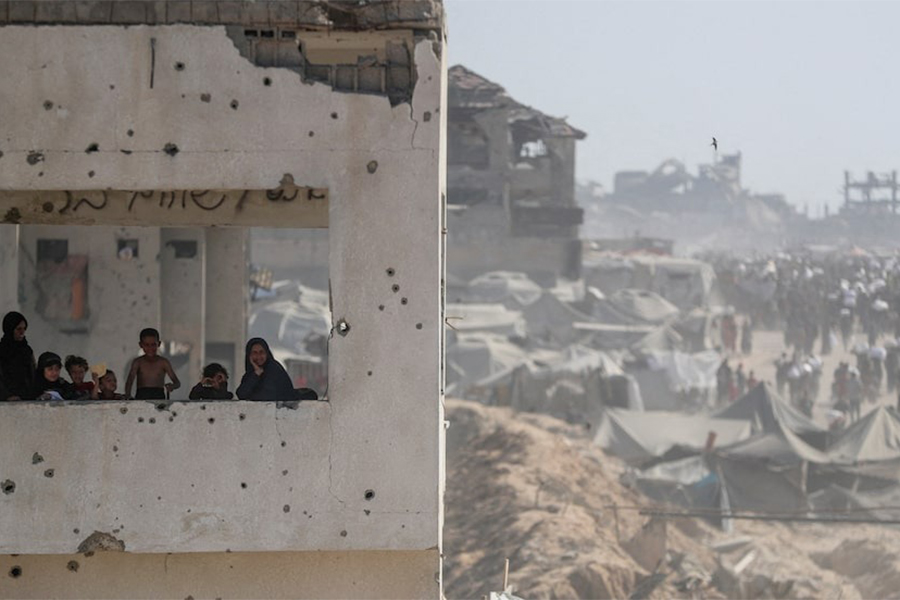 Women and children look out from a damaged building as Palestinians carry aid supplies that entered Gaza through Israel, in Beit Lahia, northern Gaza Strip on August 2, 2025 — Reuters photo