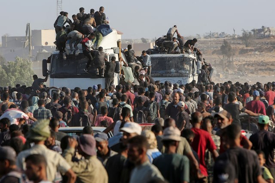 Palestinians climb onto trucks as they seek aid supplies in Khan Younis, southern Gaza Strip, August 4, 2025.