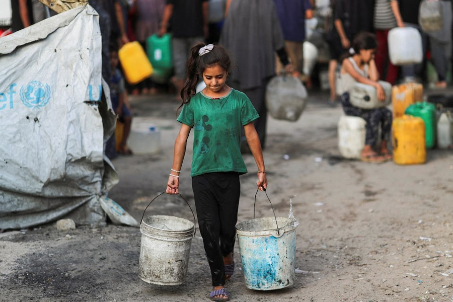 A Palestinian girl carries buckets of water amid shortages, in Gaza City August 6, 2025.