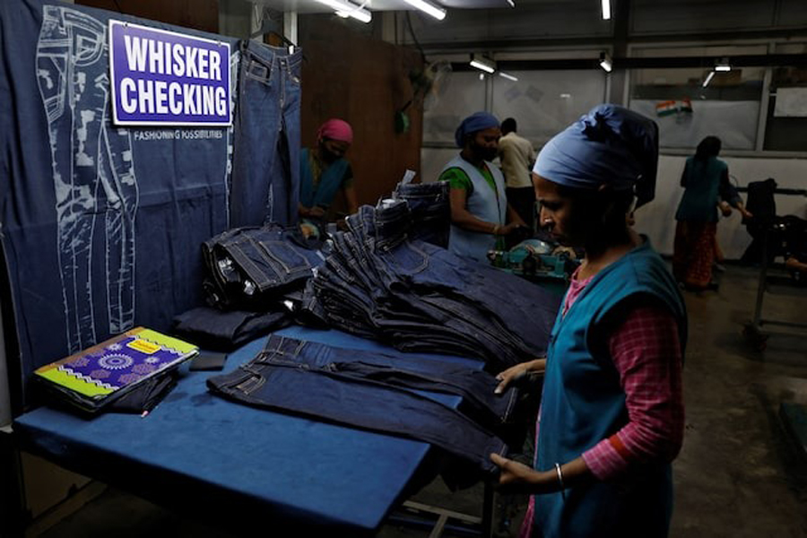 A worker makes final checks on jeans pants before packaging in a garment manufacturing unit on the outskirts of Ahmedabad, India, August 5, 2025.